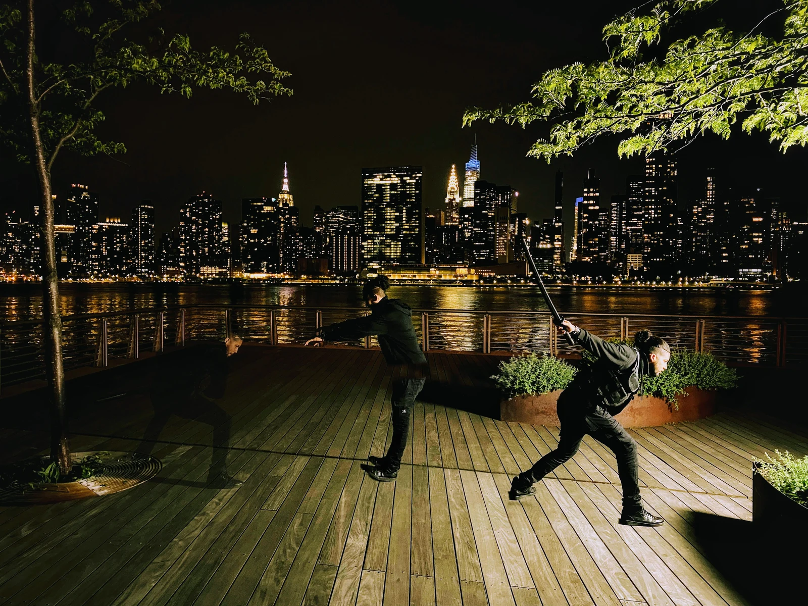 Night composite on the waterfront with the lit Manhattan skyline across the river