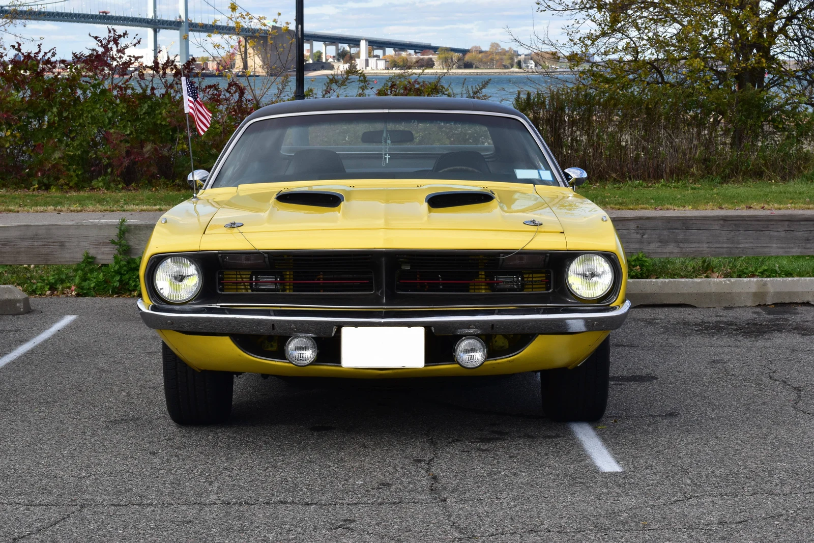 Yellow Plymouth 'Cuda parked by the bridge in daylight