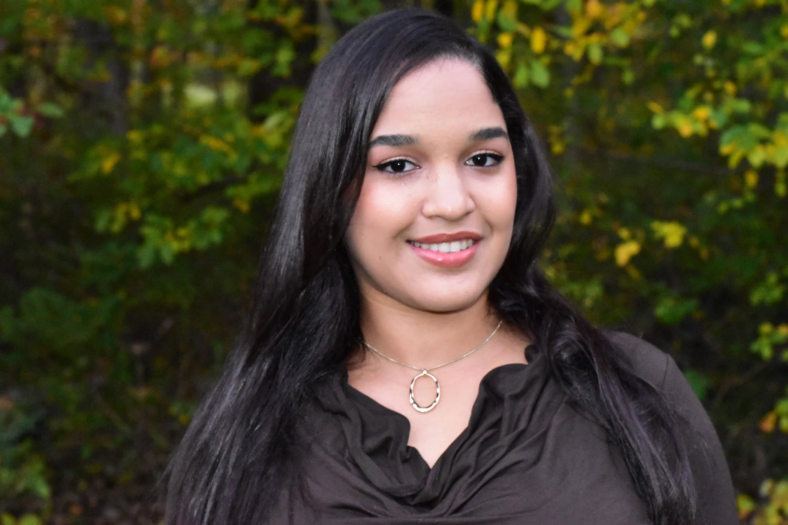 Autumn portrait of a woman smiling among warm fall foliage