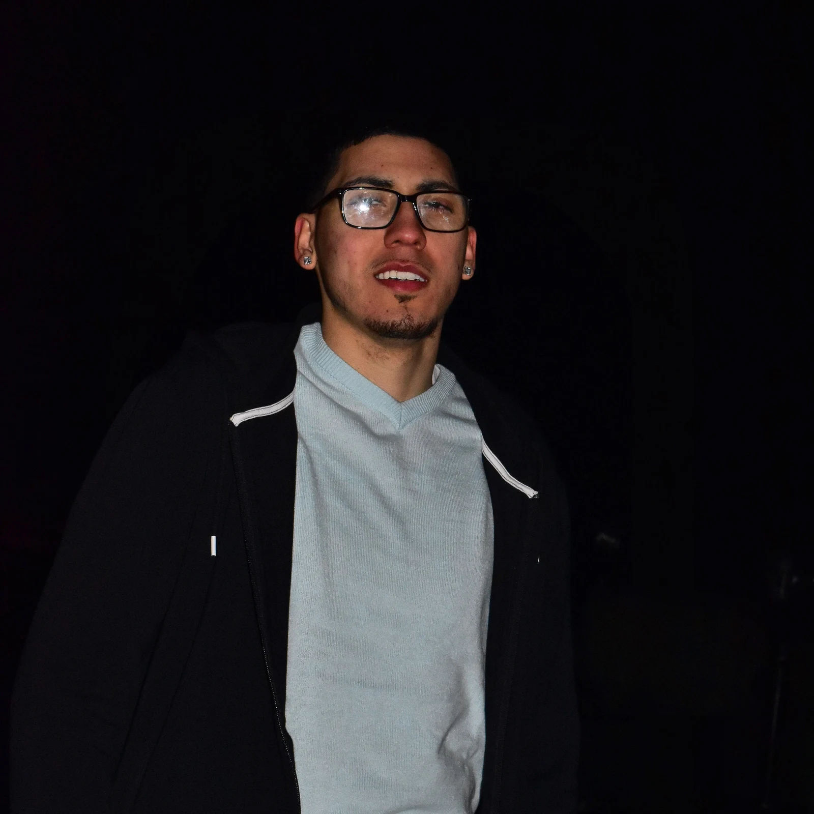 Night portrait of a young man glancing upward
