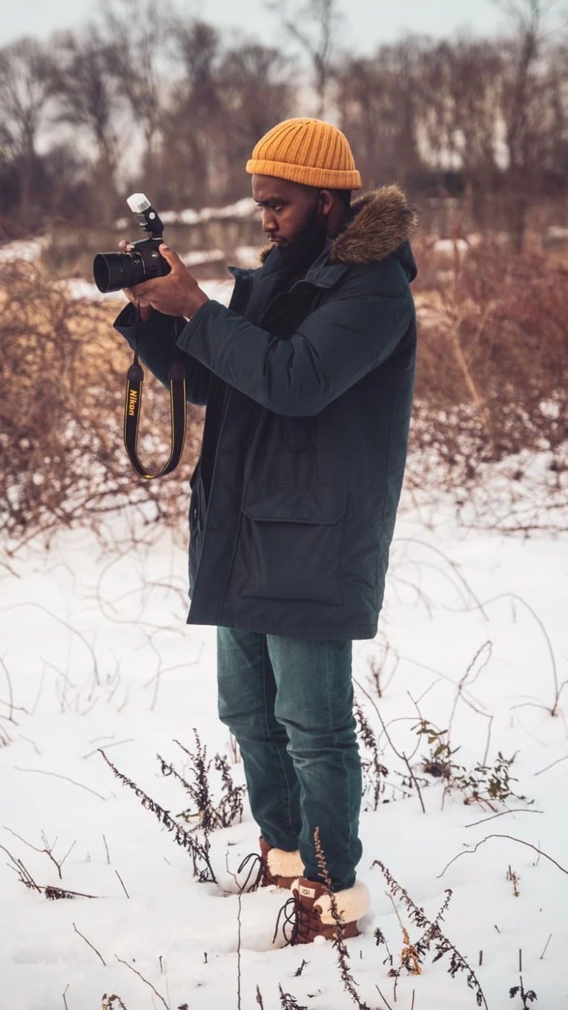 The photographer at work in a snowy field, camera raised